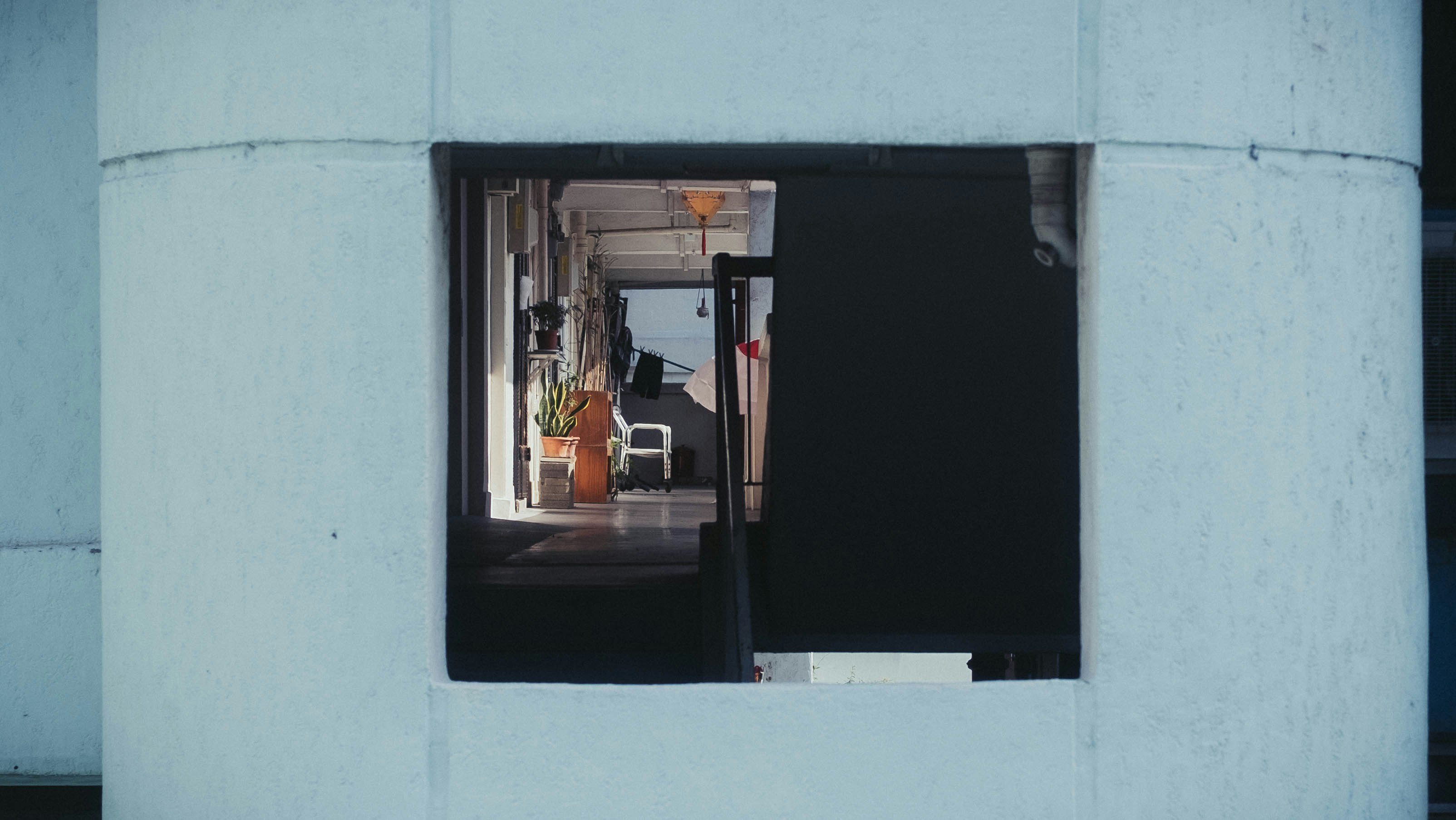 man in orange shirt standing in front of mirror